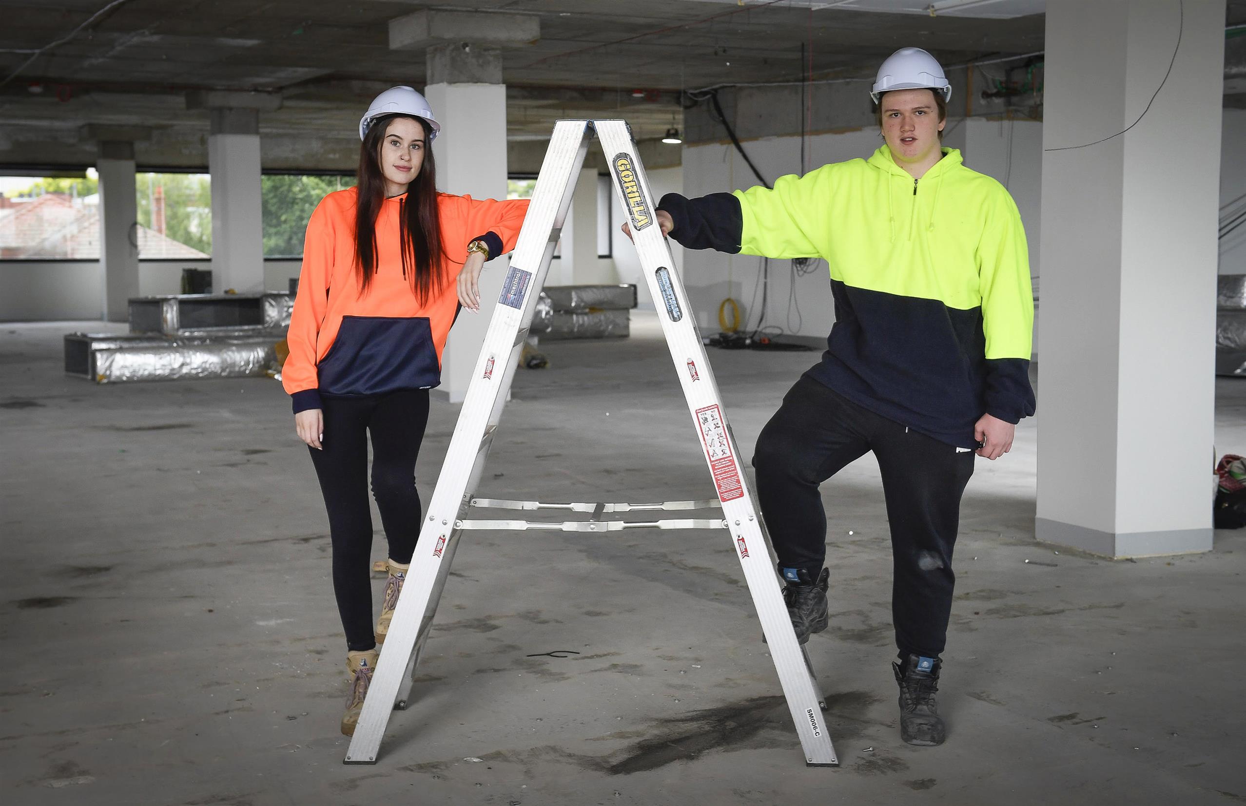 Construction apprentices next to ladder