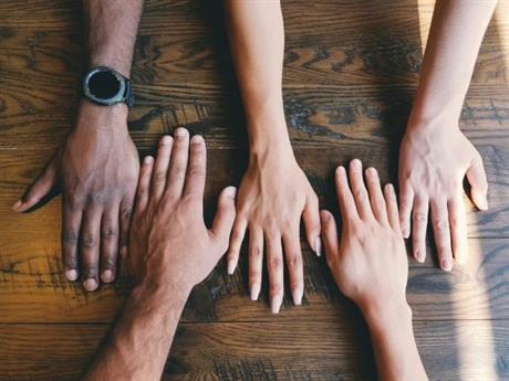 many hands resting on a table