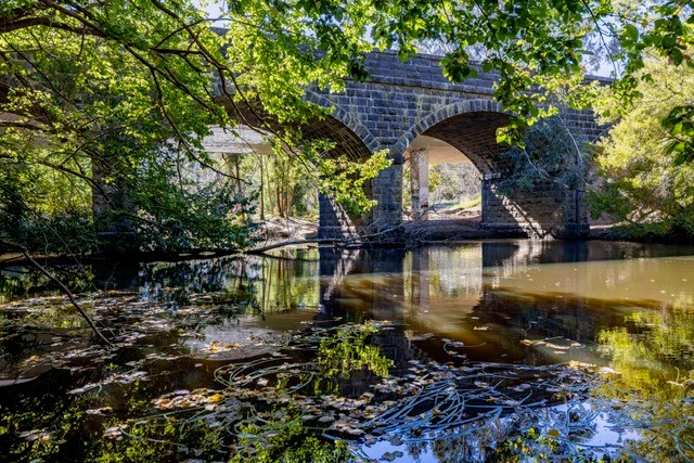 Old bluestone bridge spanning the Moorabool River in Batesford