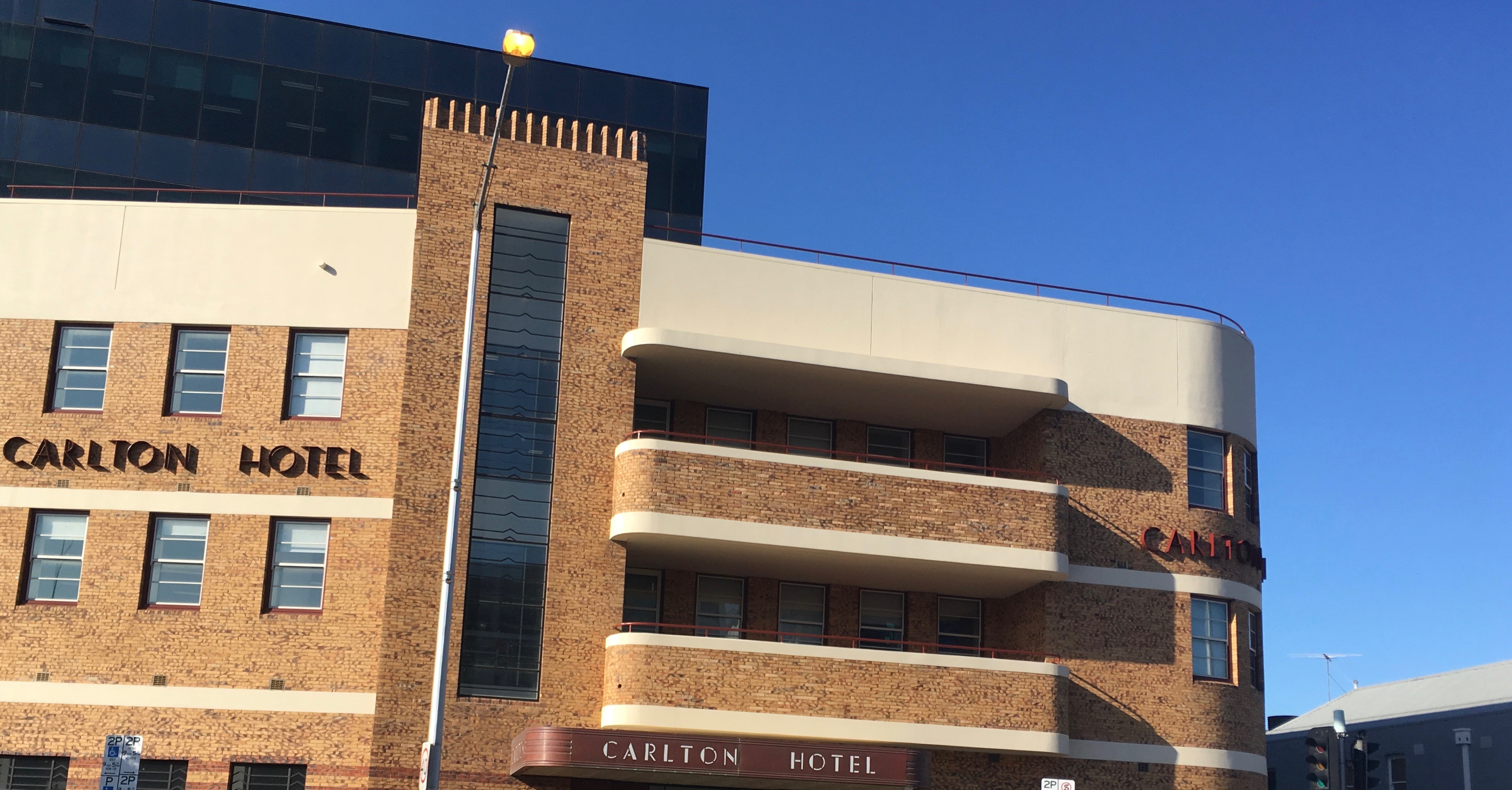 Streamlined Art Deco building built from yellow and brown brick with cream trim and roof