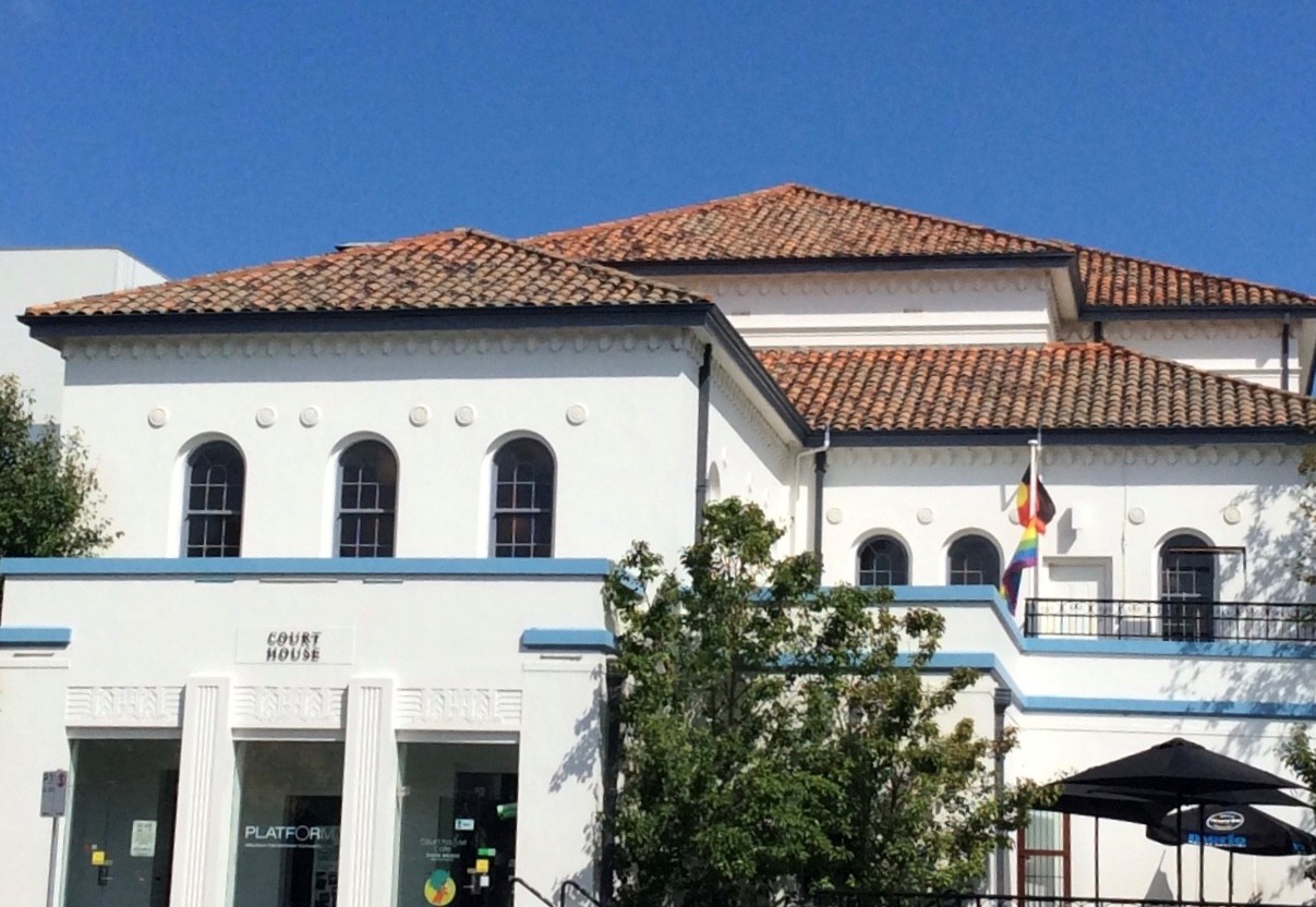 White painted period building with blue trim and brown tile roof