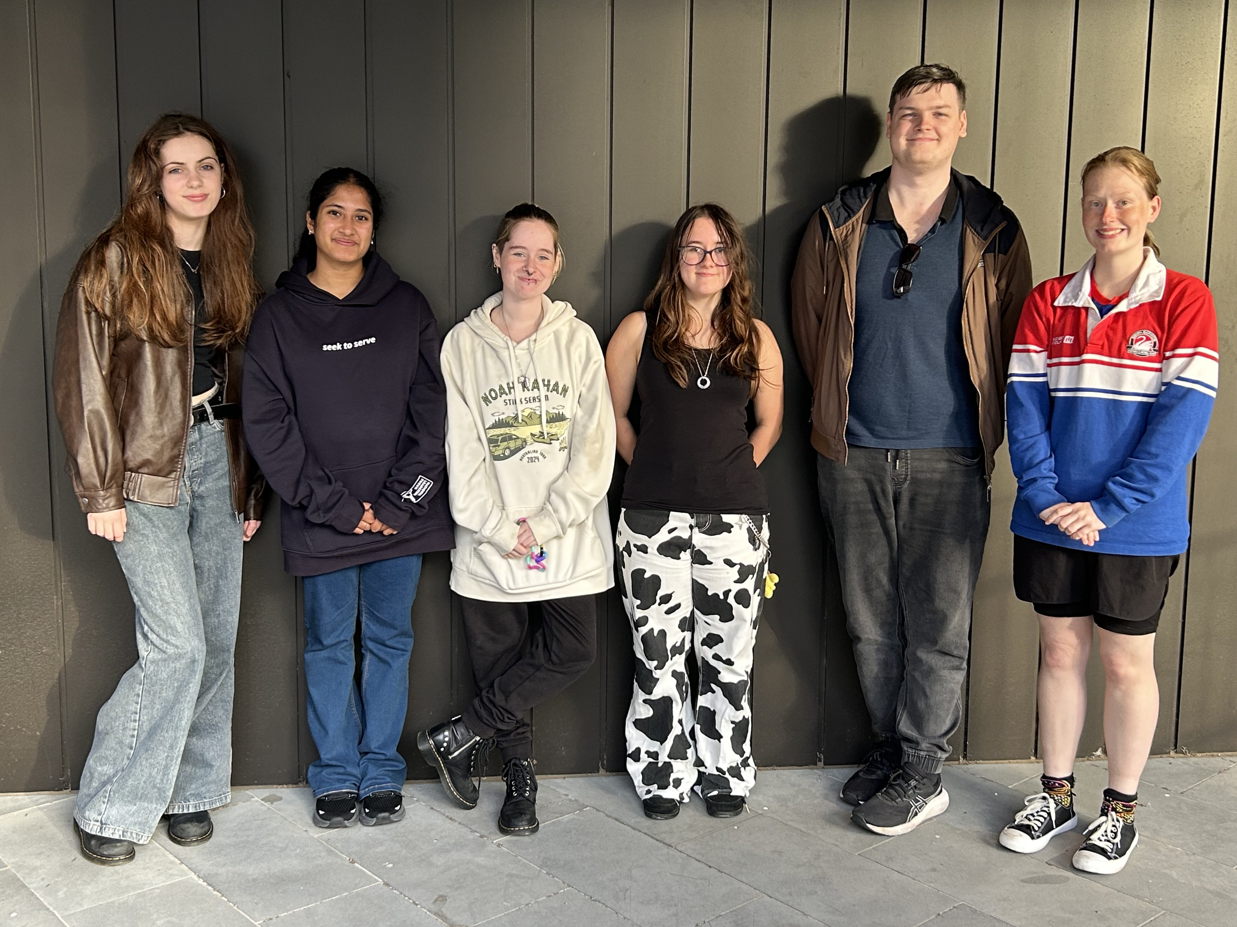 Young people standing in a line smiling