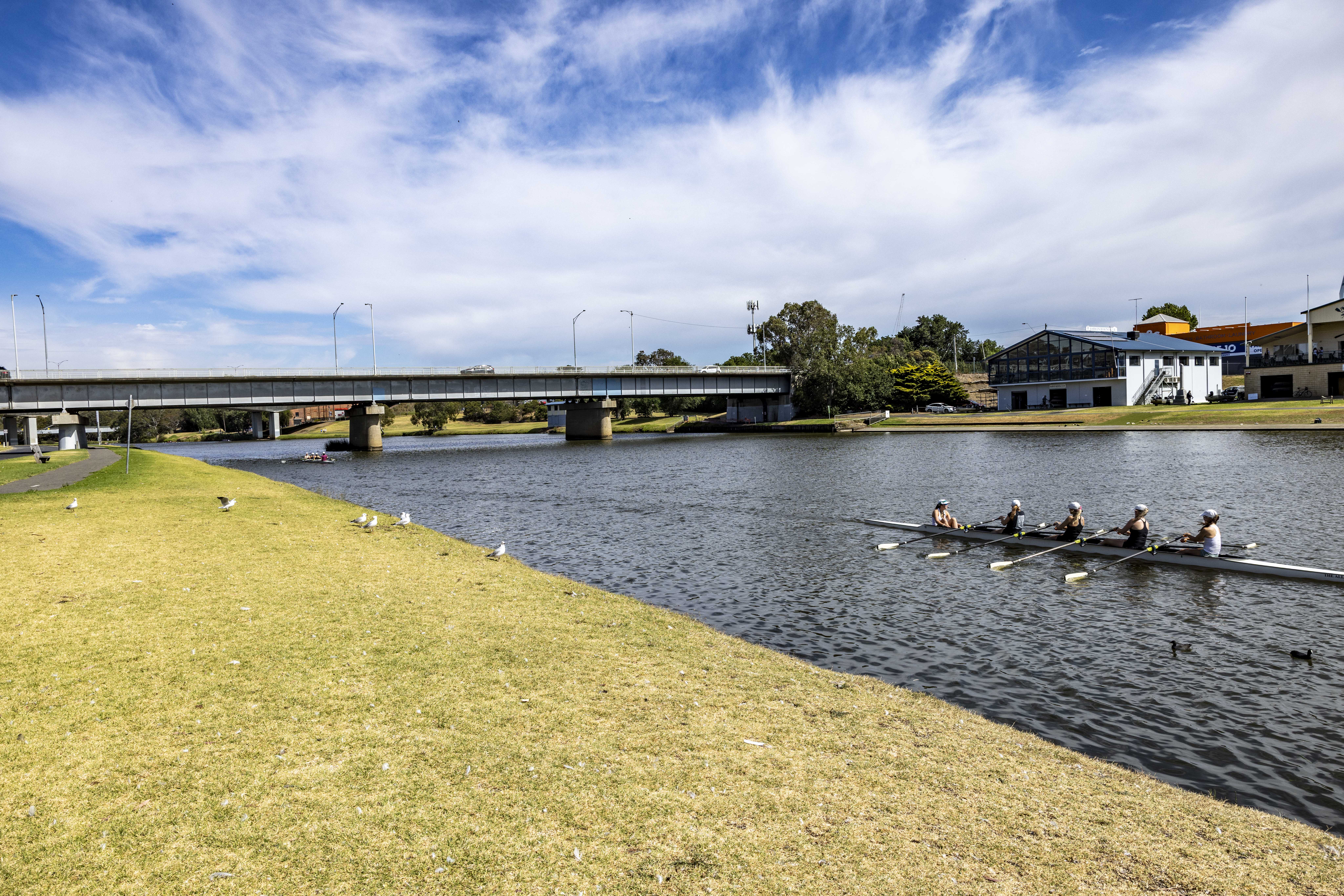 Bridge across the Barwon River with a team of rowers on the water