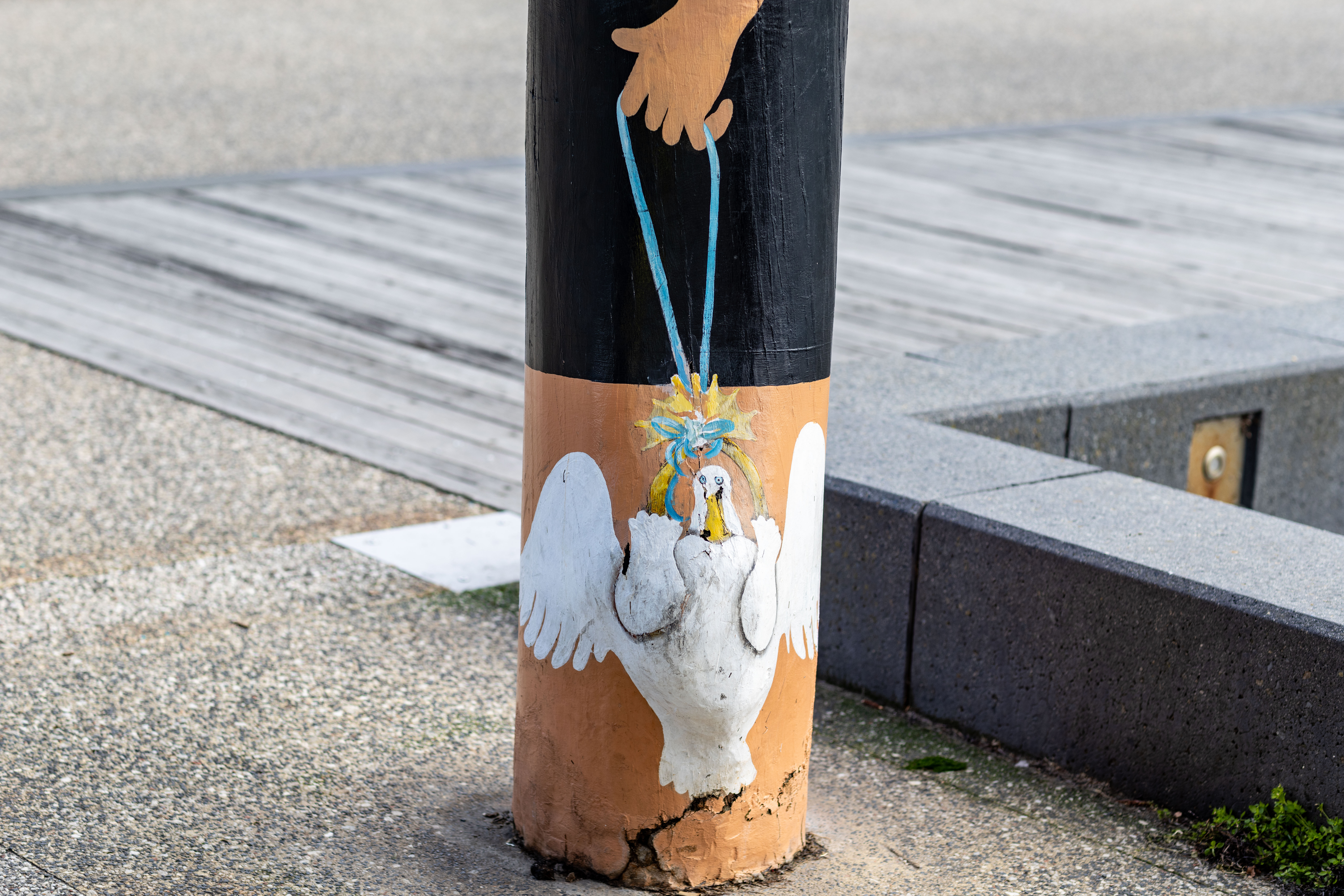 White duck at the base of a bollard
