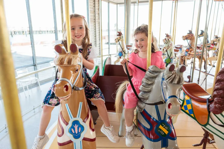 Parka, six, and Sophie, four, enjoy a ride at popular City of Greater Geelong tourist attraction The Carousel.