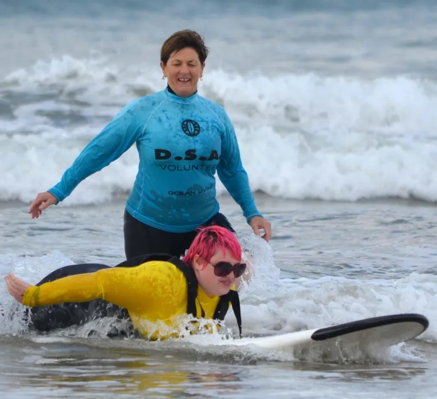 Volunteer, Cheryl, watches on as surfer, AJ, rides in on a wave (Photo credit: dianasphotos)