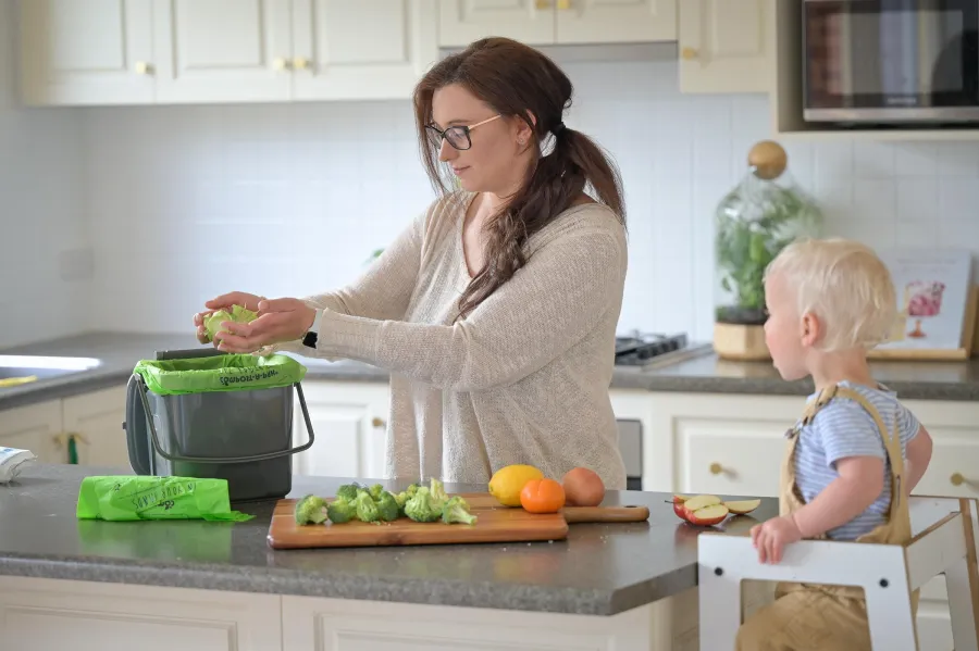 Kayla using the new kitchen caddy as part of the food waste trial in Lara