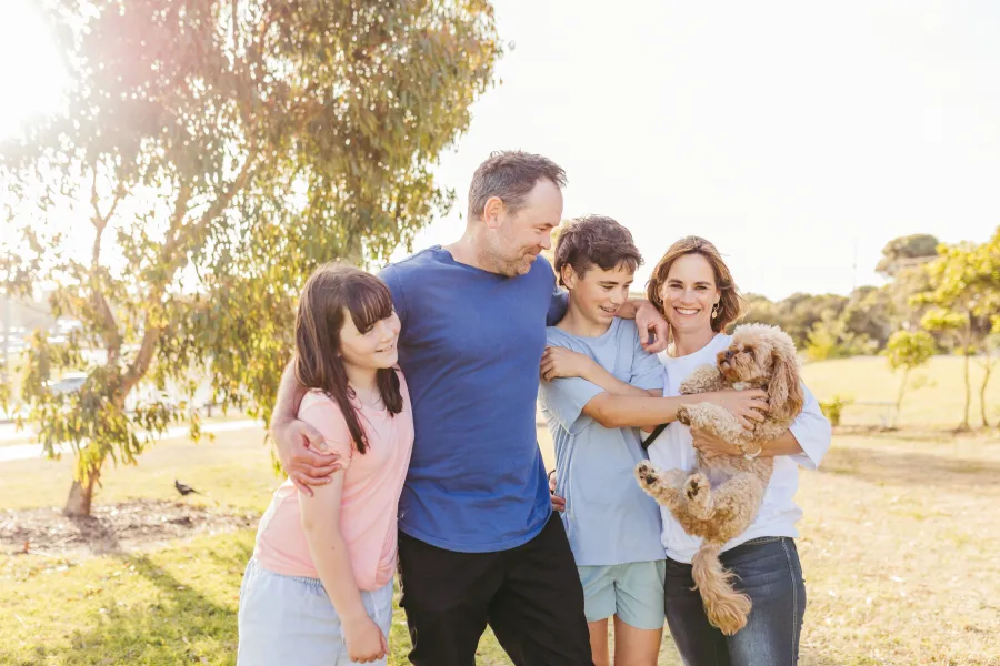 Happy family in a park with their pet dog.