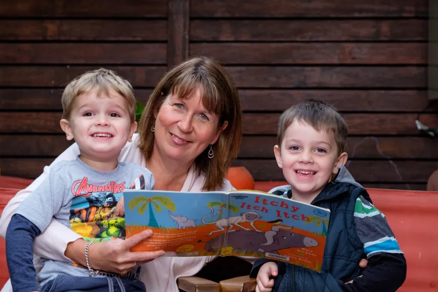 Educator reading to children in home.