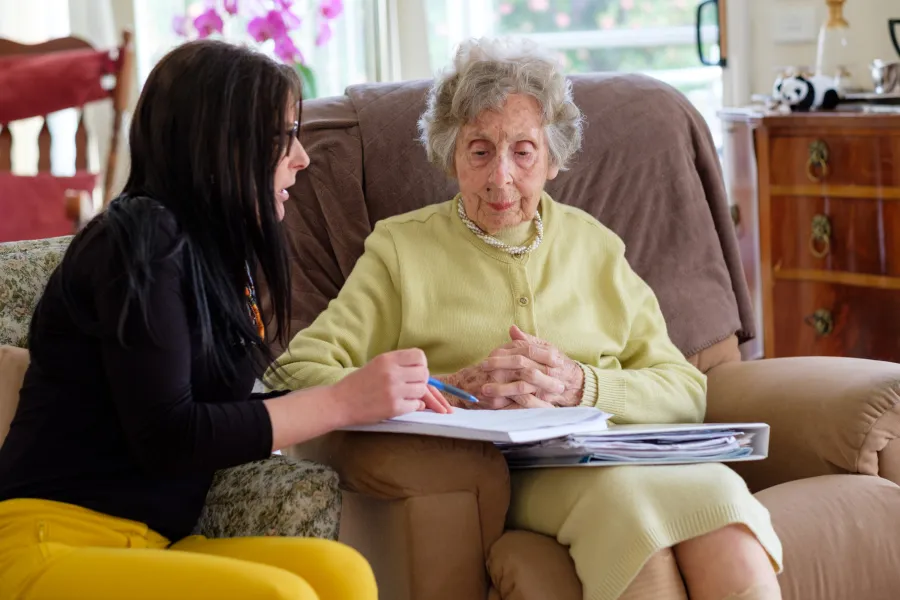 Senior woman discussing care needs with worker.