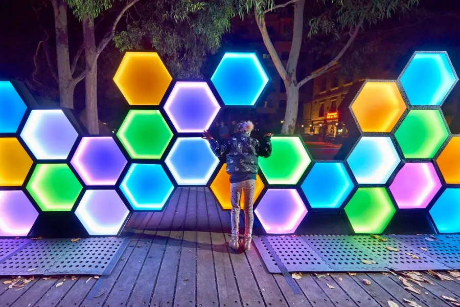 Sculpture of multicoloured hexagonal lights on boardwalk