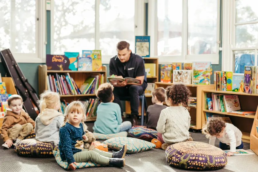 A City of Greater Geelong family services employee reading a book to a group of children