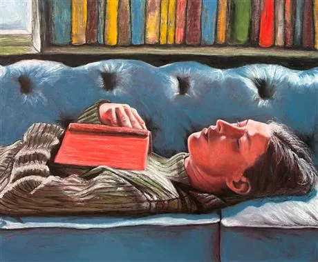 Man lying on couch with book on chest