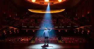 Melbourne International Comedy Festival Man standing on stage under spotlight