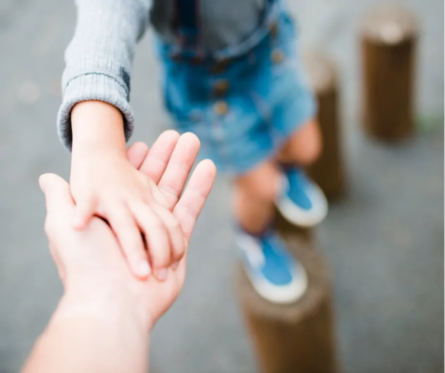 Young Parents Connect Adult hand reaching out to a child hand.