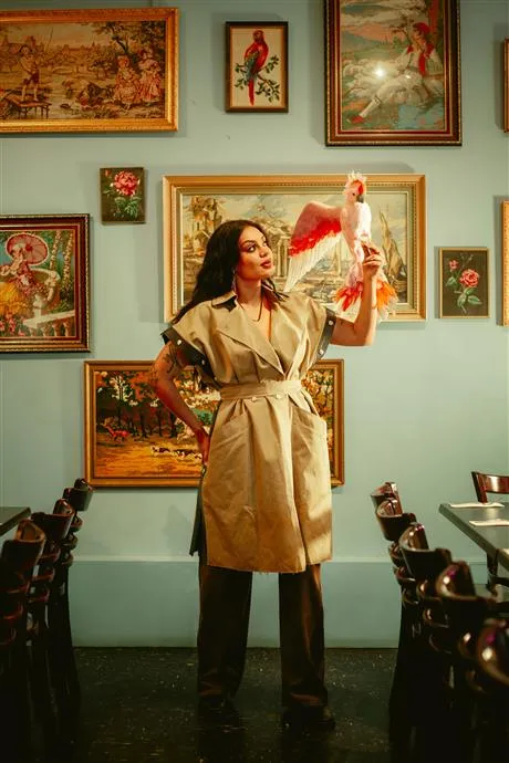 Image of Thelma Plum standing in front of a wall of art