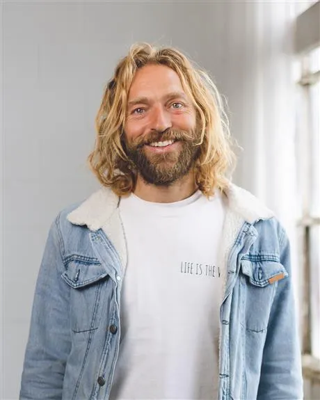 Image of Tom Robb smiling with denim jacket on
