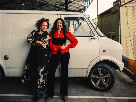 Image of Vika and Linda standing in front of a white van