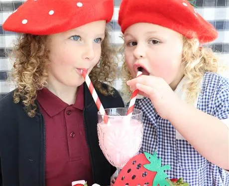 children drinking a strawberry milkshake