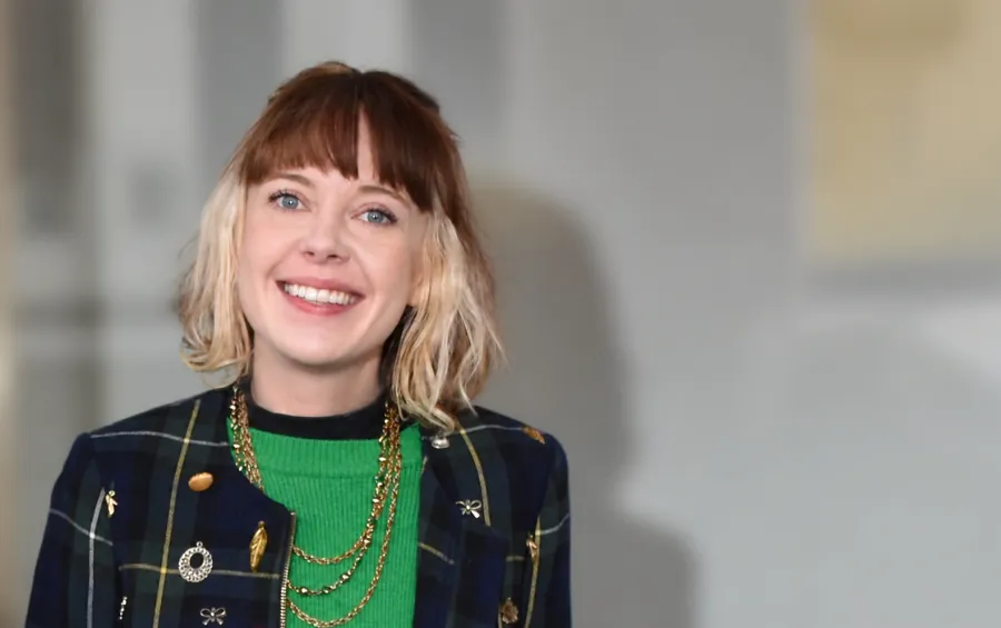 Photo of upcycling artist Emily Rastas with a black jacket and green top
