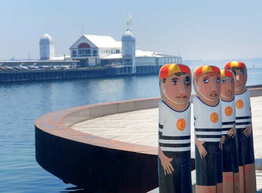 Geelong Baths Swimming Club Four painted bollards of the Geelong Baths Swimming Club. Each bollard is painted with a red and yellow swim cap and blue and white striped swimsuits.