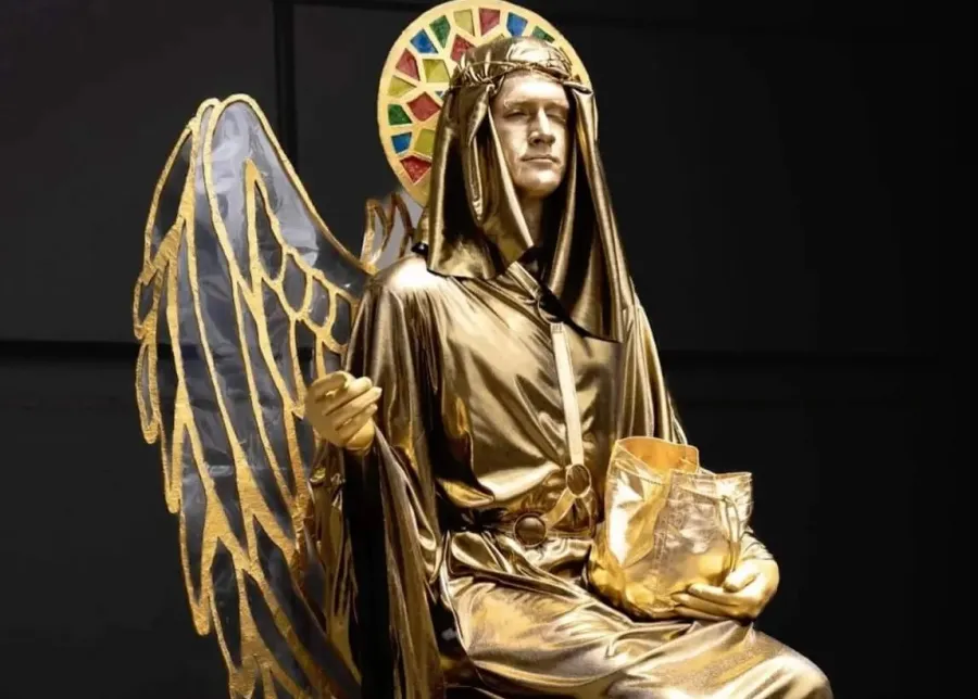 Local artist - Lazarus Gordon Person dressed as golden angel with golden face paint and halo behind their head