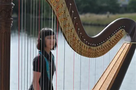 Laura Tanata Image of lady standing in front of harp
