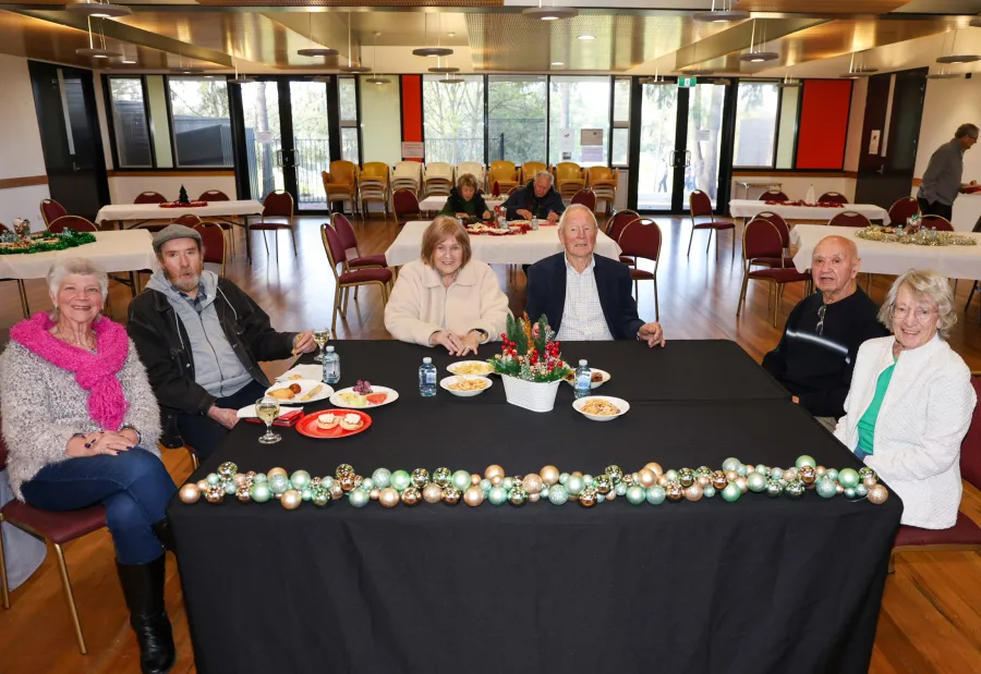 People sitting at a table decorated with Christmas decorations.