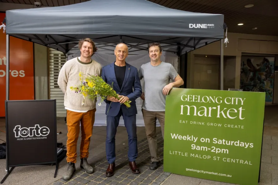 Mayor Stretch Kontelj (centre) with Simon Toohey and Kieran Blood of Barwon Events. The mayor stands in the middle holding flowers.