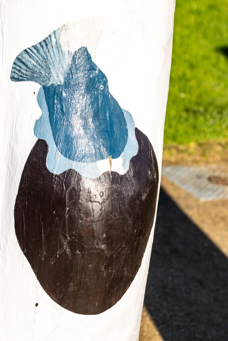 Painted brown sack with fish tail on bollard