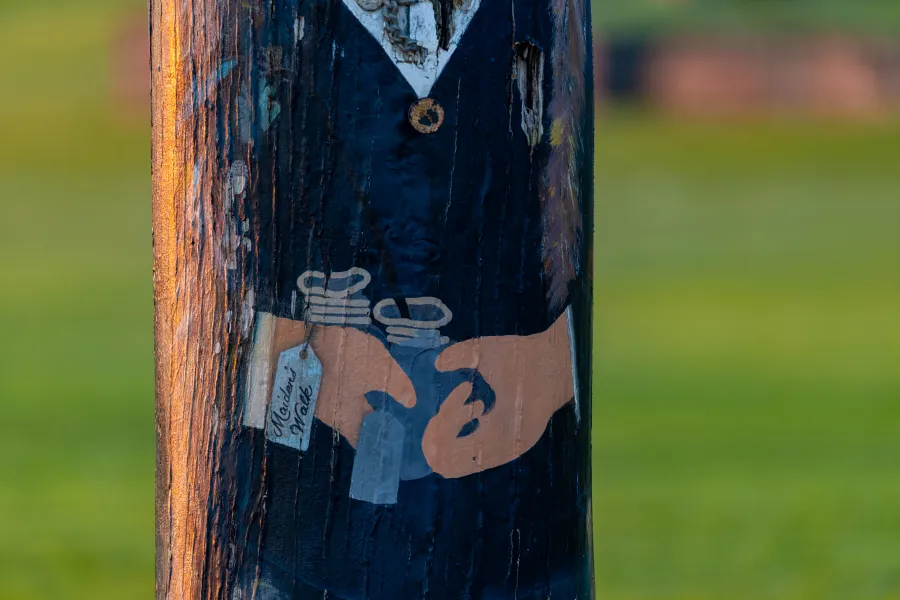 Hands holding bad of prize money painted on bollard