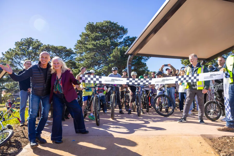 People posing before a ceremonial ribbon