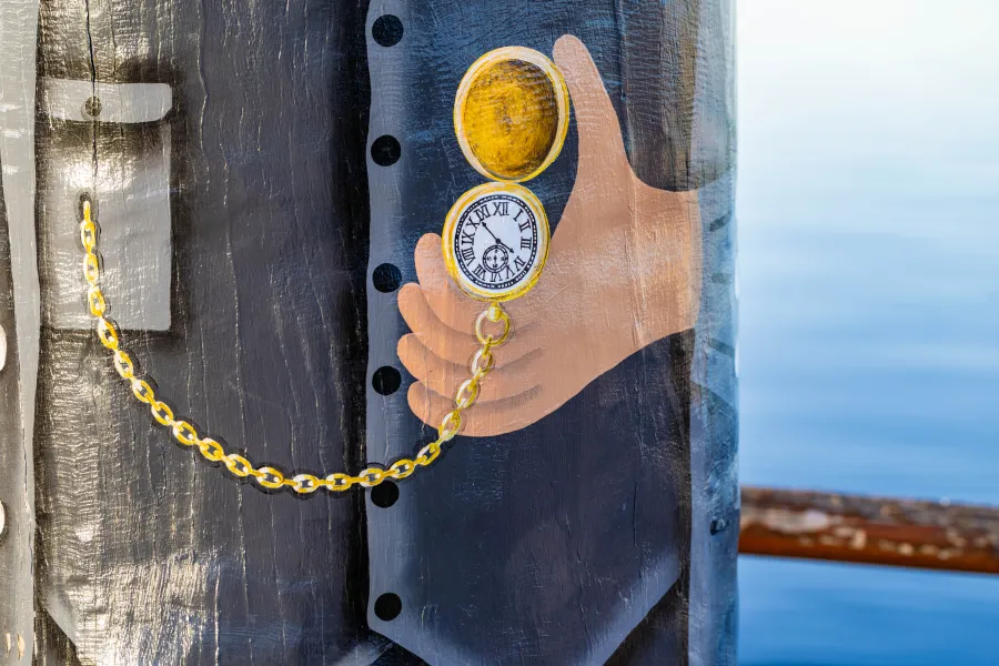 Painted pocket watch being held by bollard