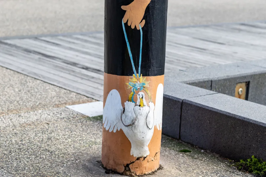 Painted duck being held by string painted on bollard