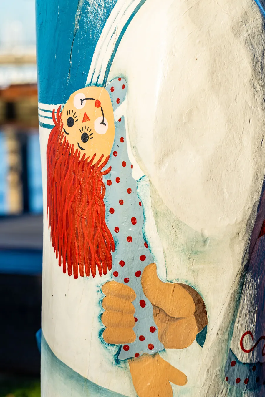 Painted rag doll held behind bollards back