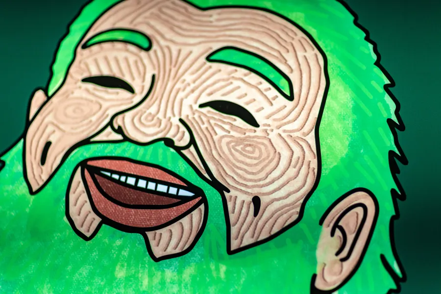 Close up of a man's fac with green beard