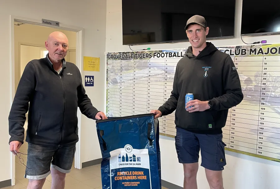 Club Treasurer Mick with member (and former AFL player) Cam Club members Mick & Cam pose with blue container deposit scheme signage.