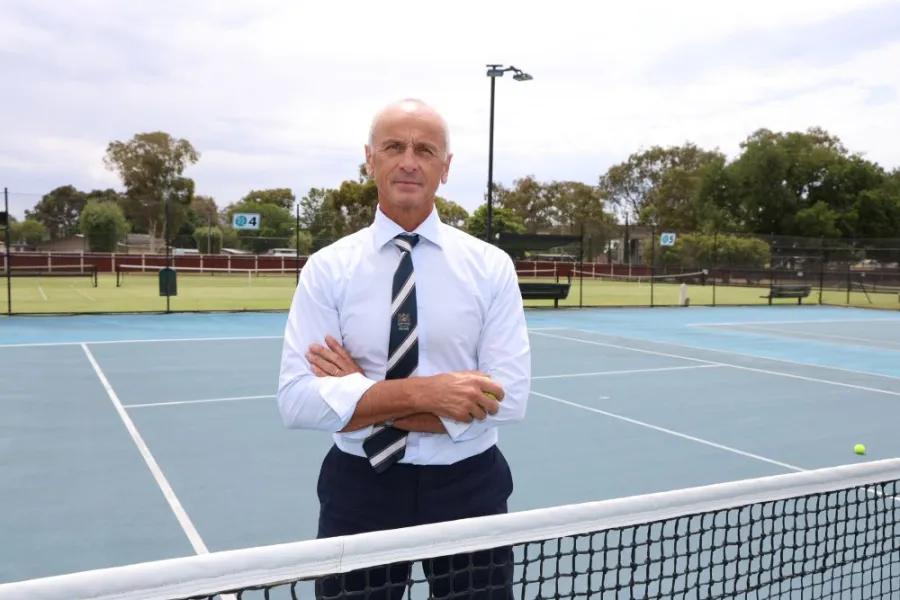 Mayor Stretch Kontelj crossing arms at the tennis net