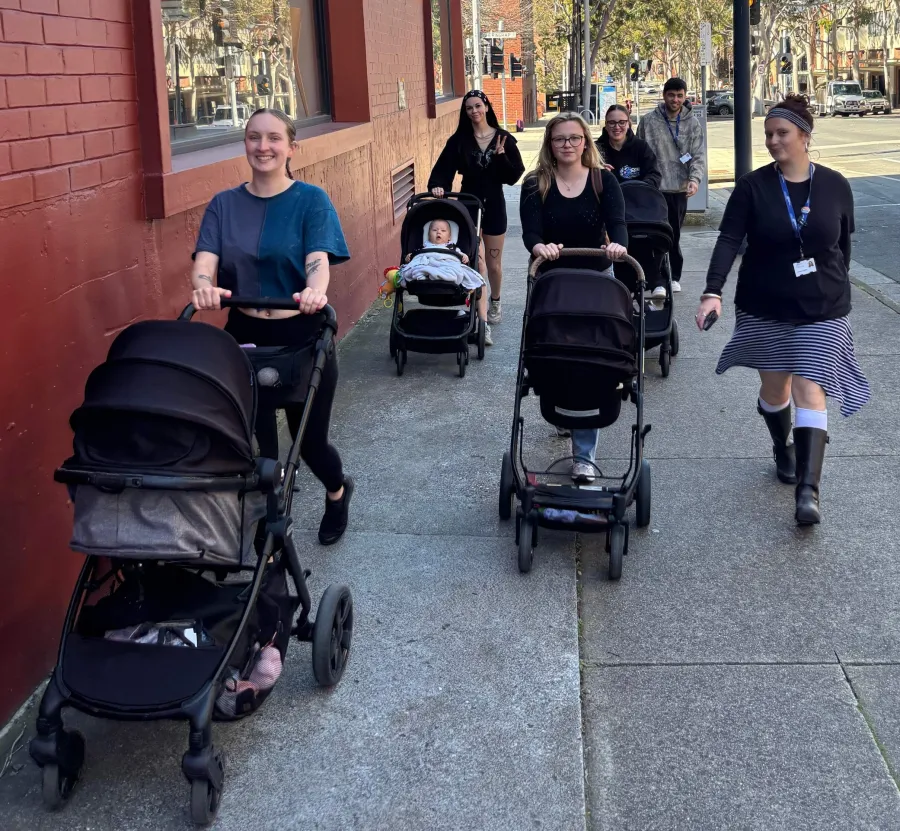 young parents walking with strollers on the street