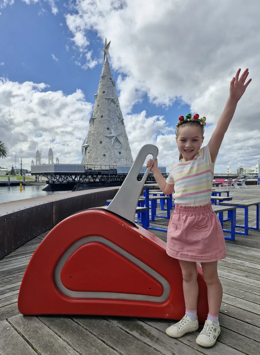 Competition winner Charlotte gets ready to flick the switch of the Floating Christmas Tree