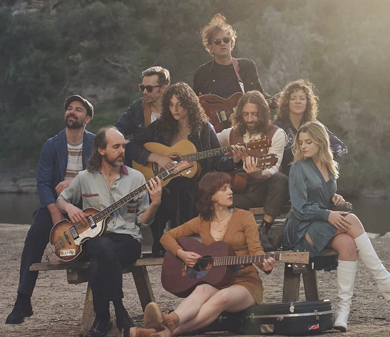 Songs from the Canyon band posing in front of trees at a park.
