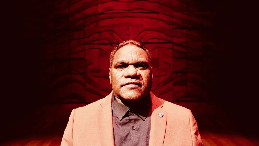 Ngulmiya posing in front of dark red wall.
