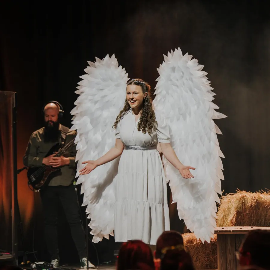 Woman dressed as angel on stage
