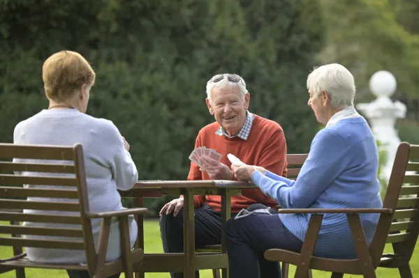 Group of senior friends playing cards at Geelong Botanic Gardens.