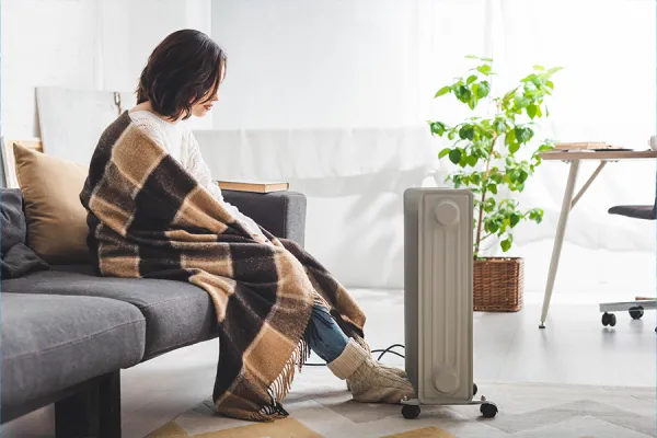 Heater Girl heating her feet against a bar heater.