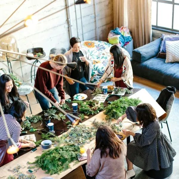Group of women arranging piles of herbs on a table