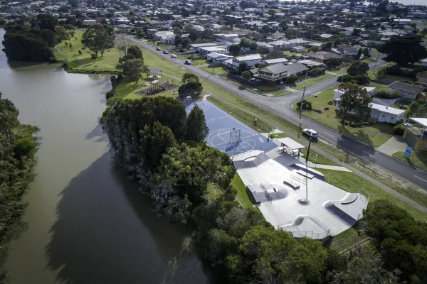 An aerial photo of a river, basketball court and green areas.