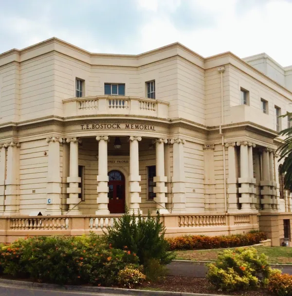 T. E. Bostock Memorial Building Heritage building with Roman style columns and small garden in front