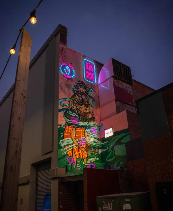 Illuminated mural of the multigenerational migrant experience