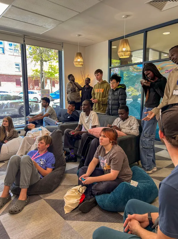Young people sitting and standing, listening to a speaker